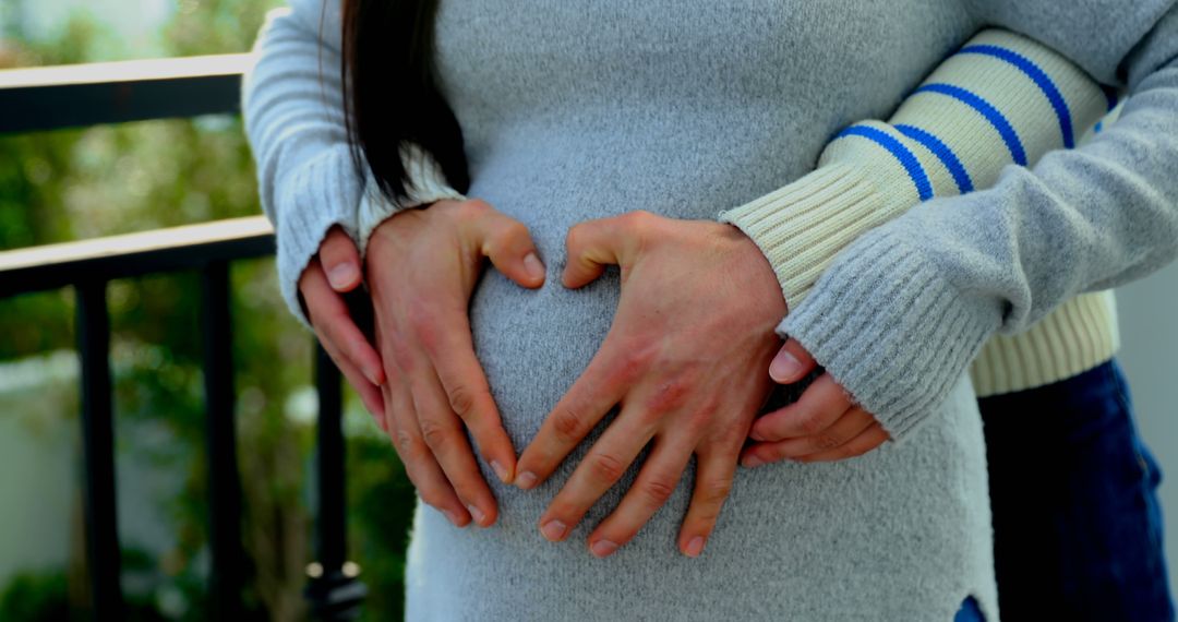 Expecting Parents Forming Heart on Pregnant Belly Outdoors - Free Images, Stock Photos and Pictures on Pikwizard.com