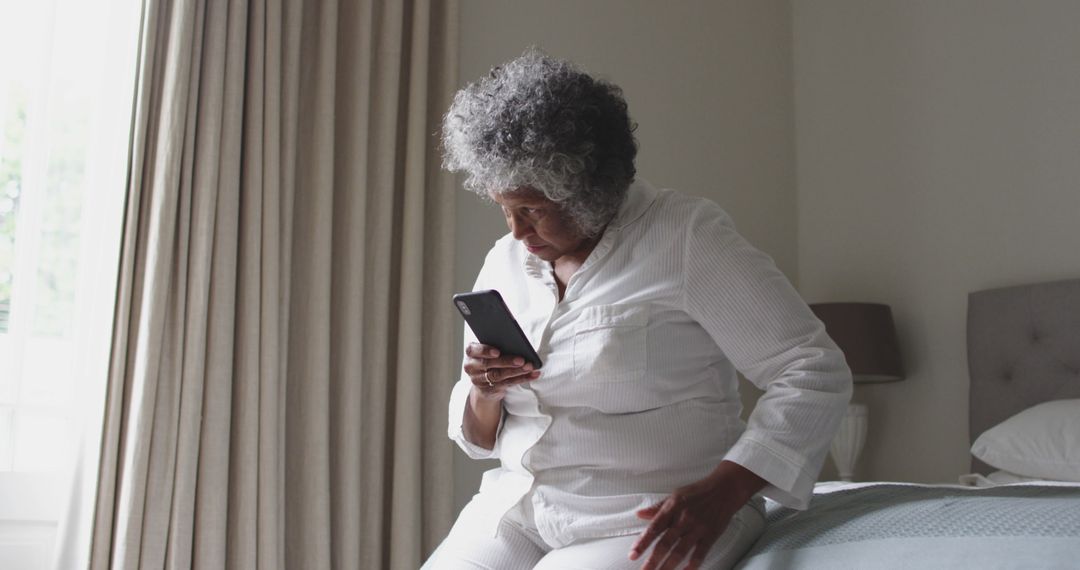 Elderly Woman Checking Phone in Morning Light - Free Images, Stock Photos and Pictures on Pikwizard.com