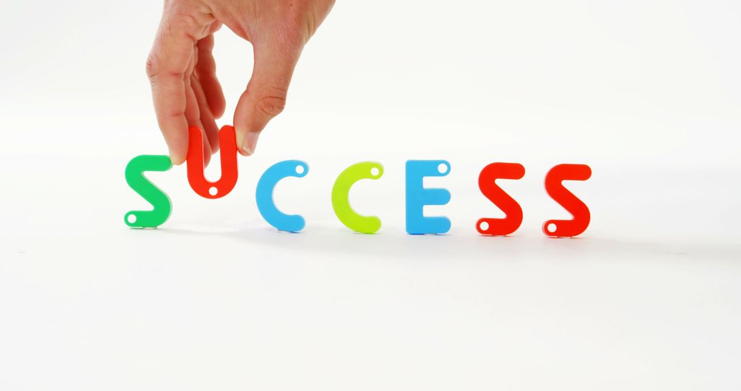 Hand Arranging Colorful Alphabet Letters Spelling Success