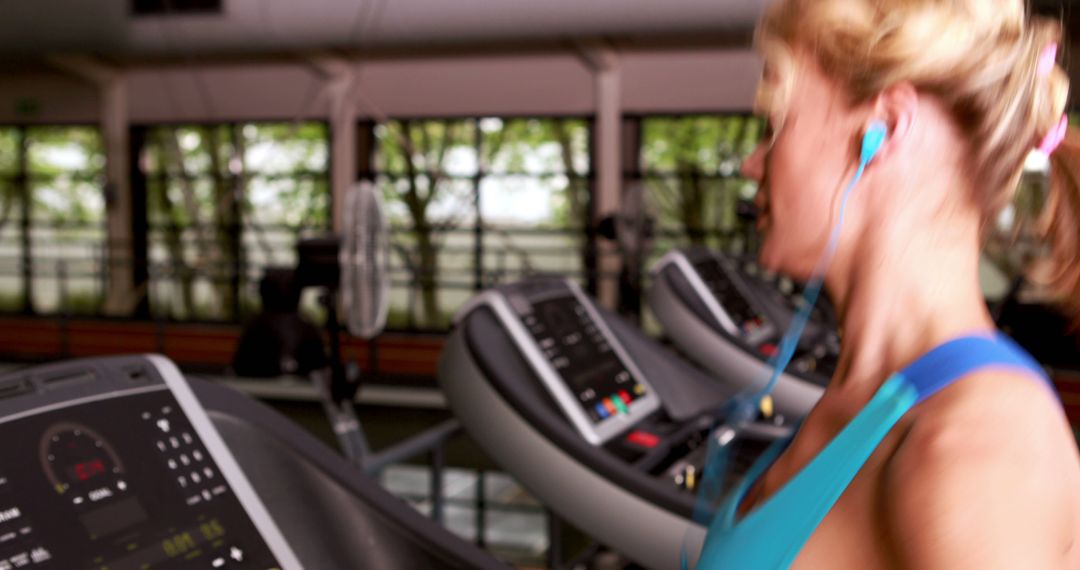 Woman Exercising on Treadmill with Headphones in Modern Gym - Free Images, Stock Photos and Pictures on Pikwizard.com