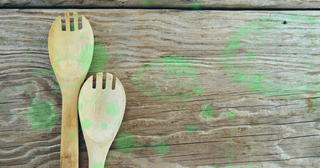 Bamboo Slotted Spoons with Green Paint on Rustic Wooden Surface