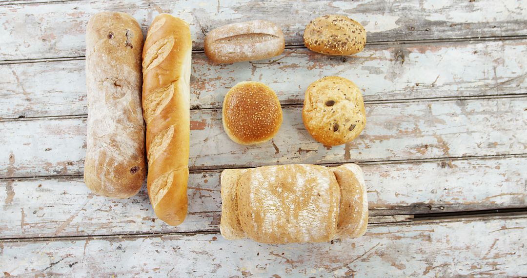 Assorted Bakery Bread Loaves on Rustic Wooden Surface - Free Images, Stock Photos and Pictures on Pikwizard.com