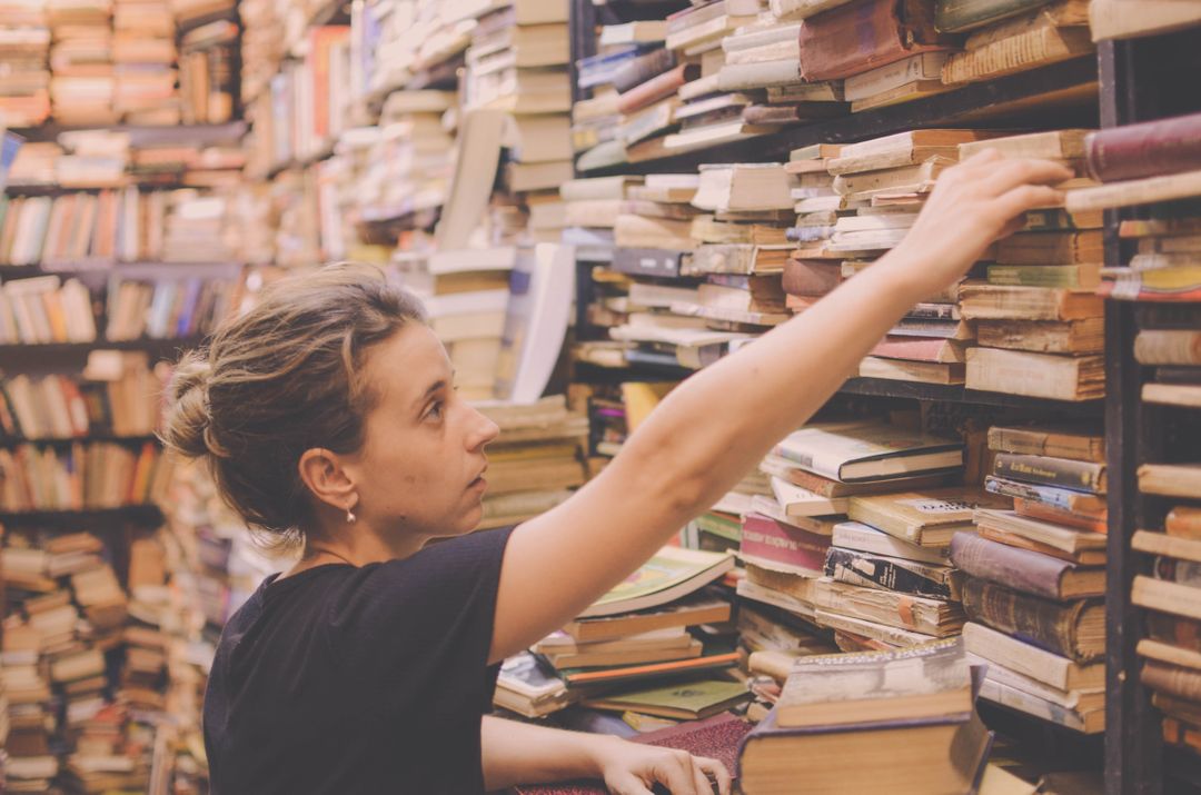 Woman Searching Stack of Old Books in Vintage Bookstore - Free Images, Stock Photos and Pictures on Pikwizard.com