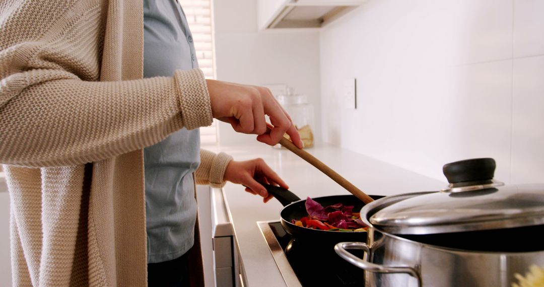 Woman Cooking with Wooden Spatula in Modern Kitchen - Free Images, Stock Photos and Pictures on Pikwizard.com