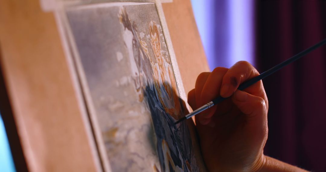Close-Up of Artist Painting Canvas in Soft Lighting