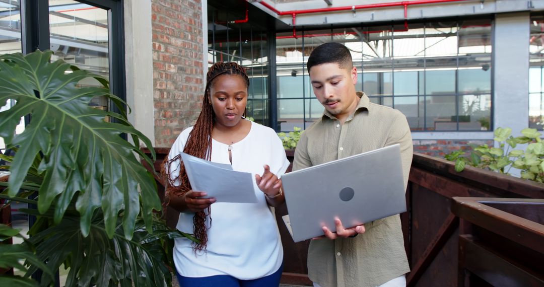 Multiracial Team Discussing Work in Modern Office Setting