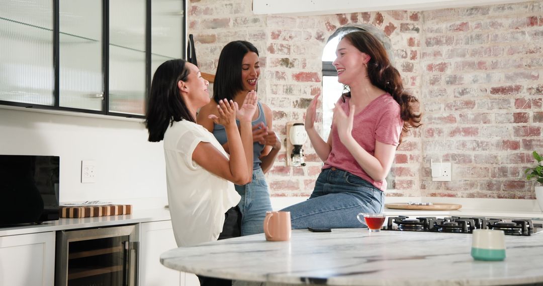 Friends Celebrating Engagement Over Tea in Bright Modern Kitchen