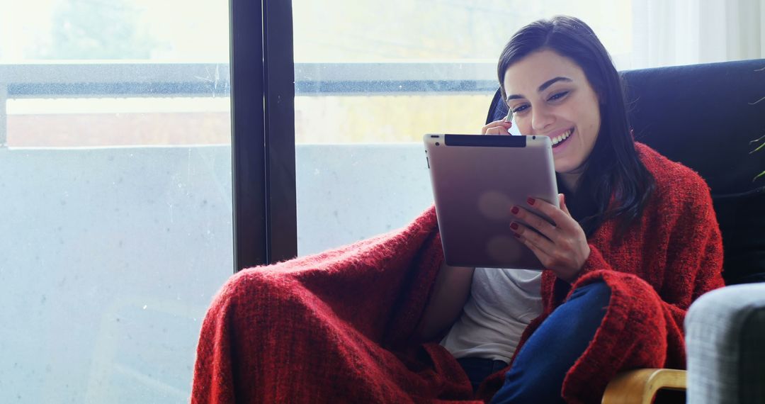 Smiling Woman Relaxing at Home with Digital Tablet - Free Images, Stock Photos and Pictures on Pikwizard.com