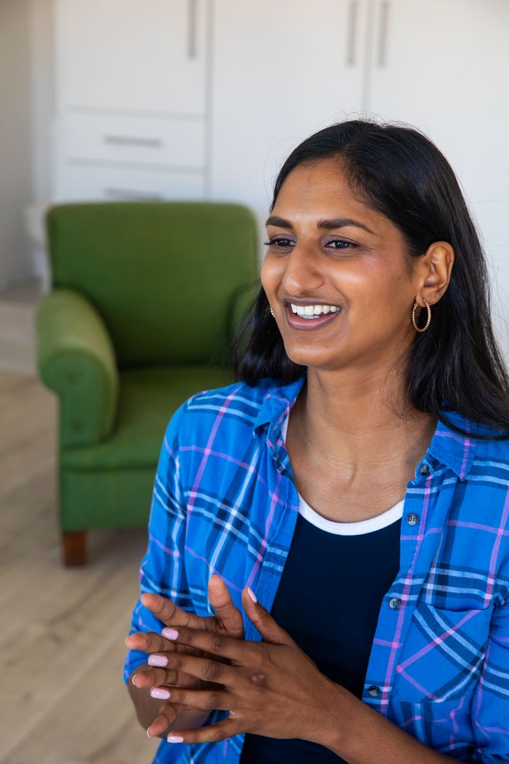 Confident Indian Woman Gesturing in Cozy Living Room Interior