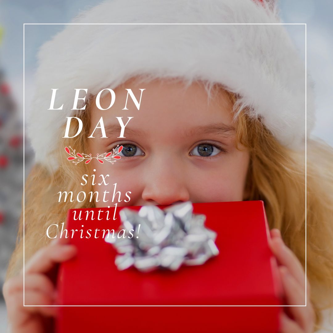 Excited Child Holding Gift Box for Leon Day Celebration