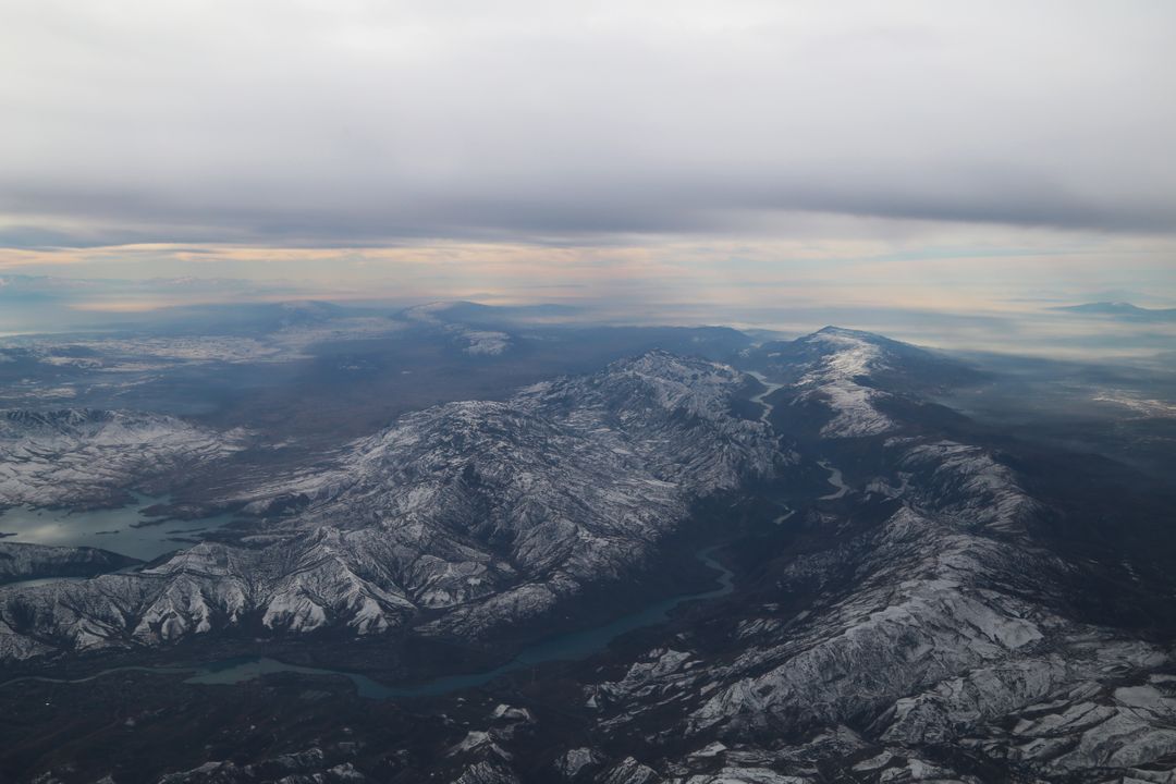 Aerial View of Snow-Covered Mountain Range Under Cloudy Sky - Free Images, Stock Photos and Pictures on Pikwizard.com