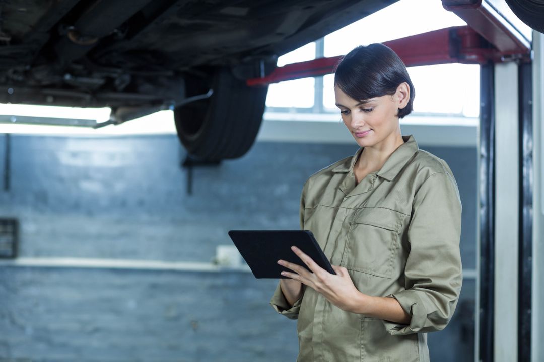 Female Mechanic Using Tablet in Automotive Garage