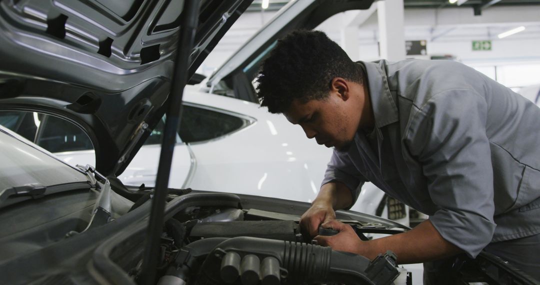 Mechanic Working Attentively on Car Engine in Garage - Free Images, Stock Photos and Pictures on Pikwizard.com