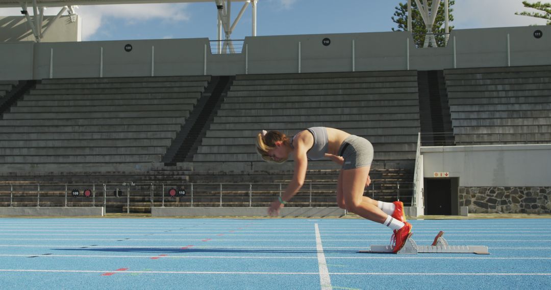 Female Athlete Preparing for Sprint on Outdoor Track - Free Images, Stock Photos and Pictures on Pikwizard.com