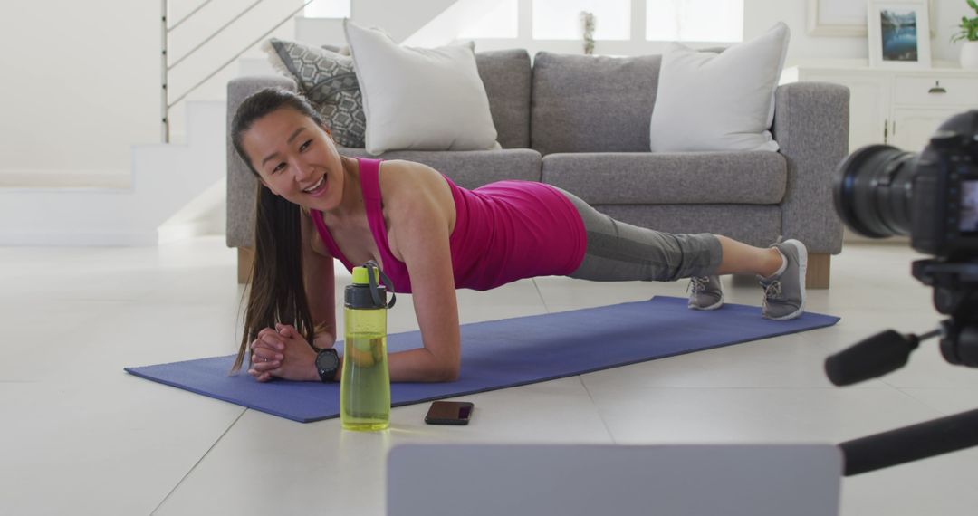 Woman Practicing Plank Exercise During At-Home Workout Video - Free Images, Stock Photos and Pictures on Pikwizard.com