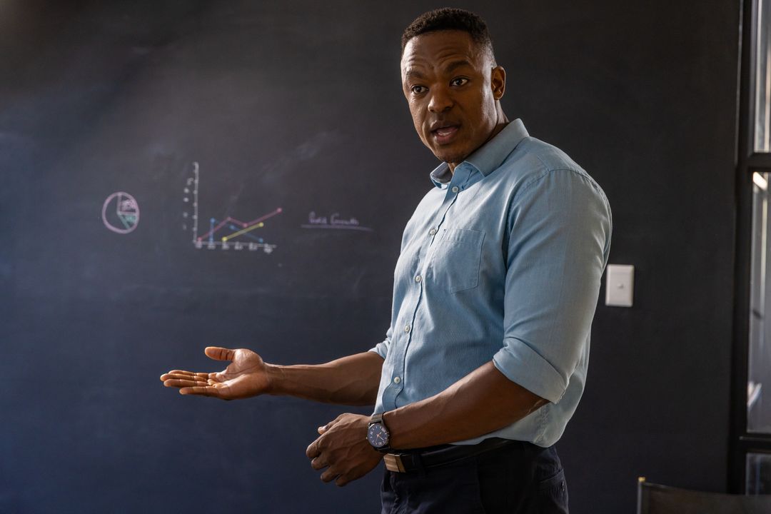 Professional Educator Presenting Data on Chalkboard