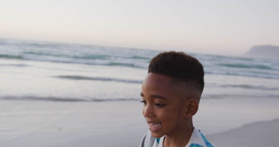 Joyful African American boy playing on beach at sunset - Free Images, Stock Photos and Pictures on Pikwizard.com