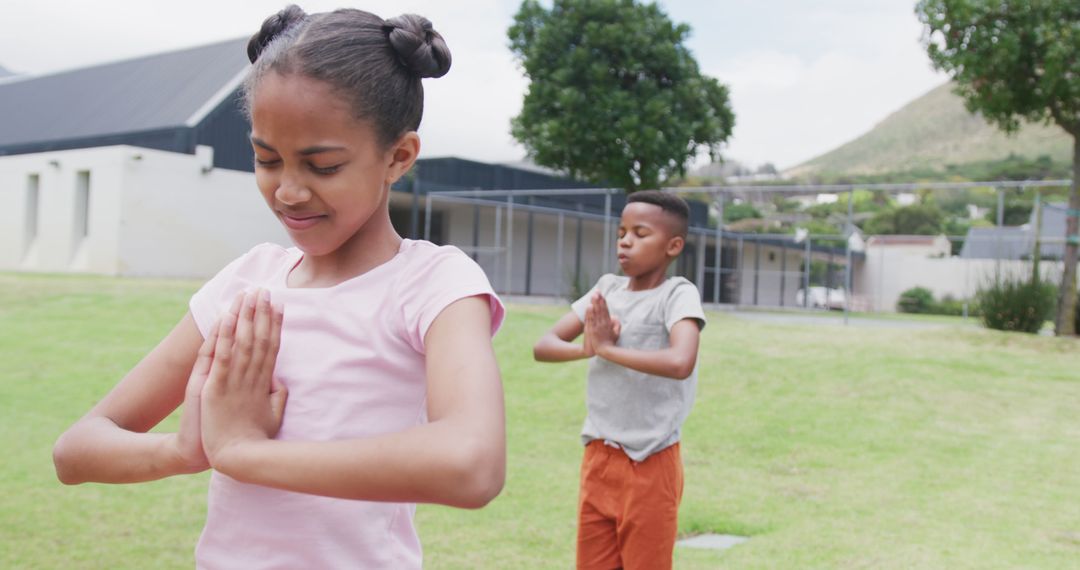 Two smiling African American children practicing yoga outdoors - Free Images, Stock Photos and Pictures on Pikwizard.com