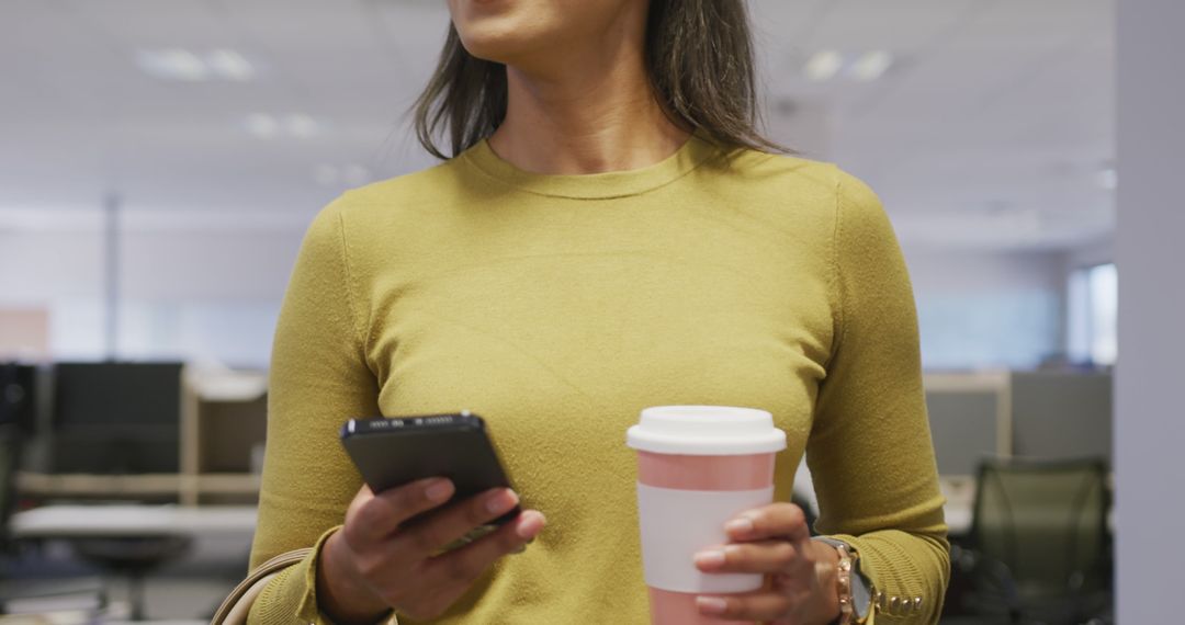 Businesswoman Smiling Holding Coffee and Smartphone Modern Office - Free Images, Stock Photos and Pictures on Pikwizard.com