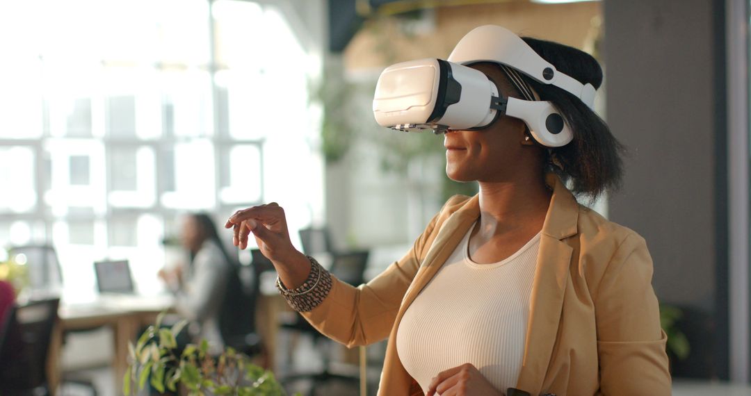 African American woman wearing VR headset interacting with virtual interface in open office