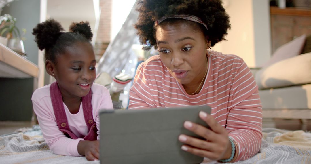 Playful Mother and Daughter Enjoying Tablet Time Together