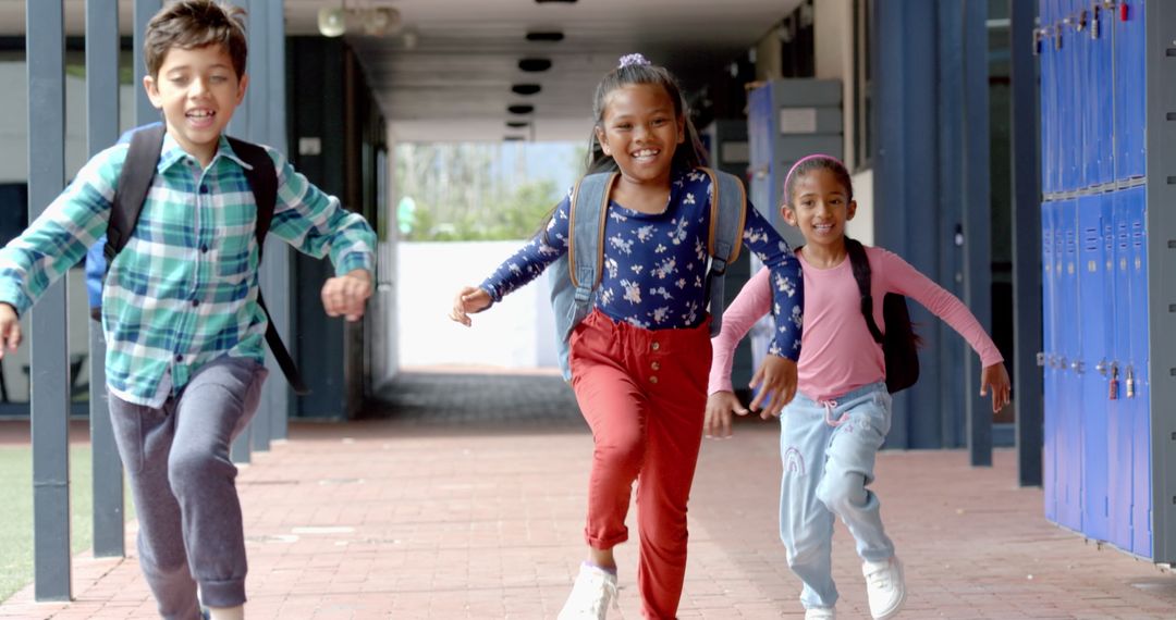 Joyful Students Running in School Hallway with Backpacks