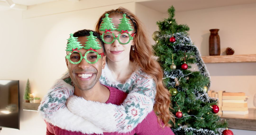 Cheerful Couple Embracing in Festive Setting with Christmas Tree Glasses