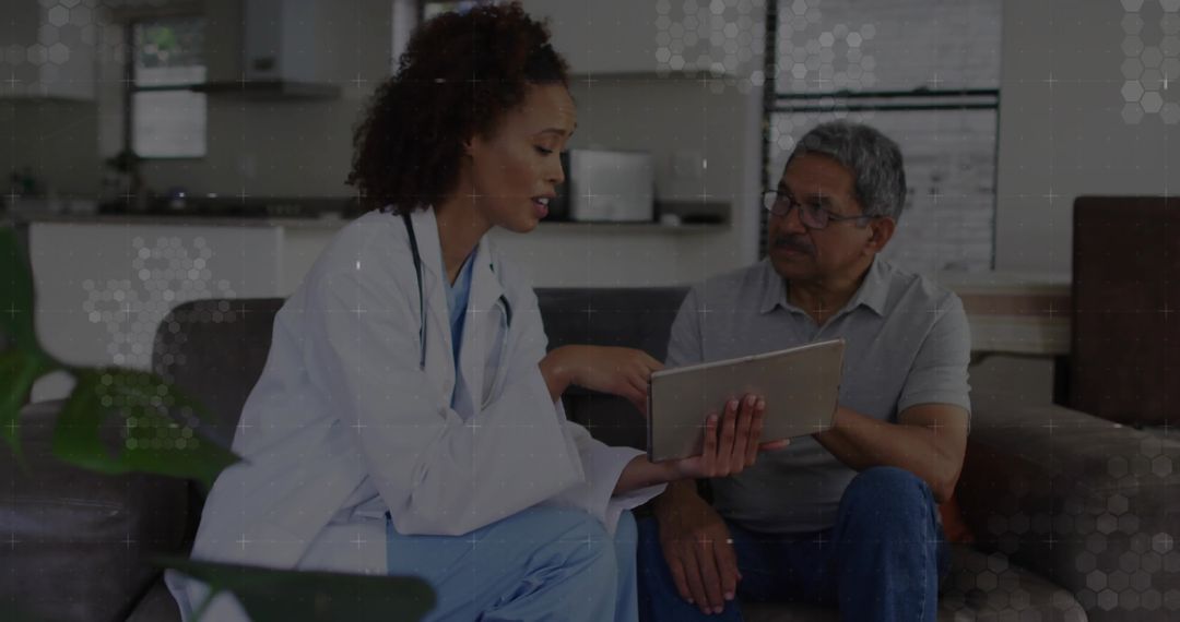 Nurse Reviewing Health Data with Senior Patient at Home Using Tablet