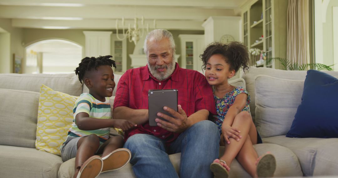 Grandfather Reading E-book to Grandchildren on Sofa - Free Images, Stock Photos and Pictures on Pikwizard.com