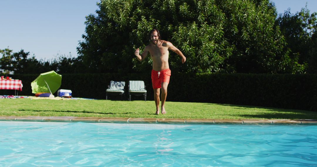 Caucasian man having fun jumping into a swimming pool - Free Images, Stock Photos and Pictures on Pikwizard.com