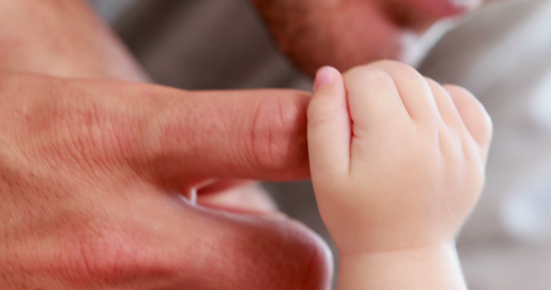 Close-Up of Baby Holding Adult Finger Indicating Strong Bond and Trust - Free Images, Stock Photos and Pictures on Pikwizard.com