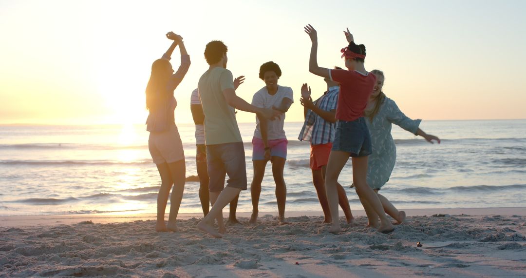 Friends Dancing on Beach at Sunset in a Festive Celebration