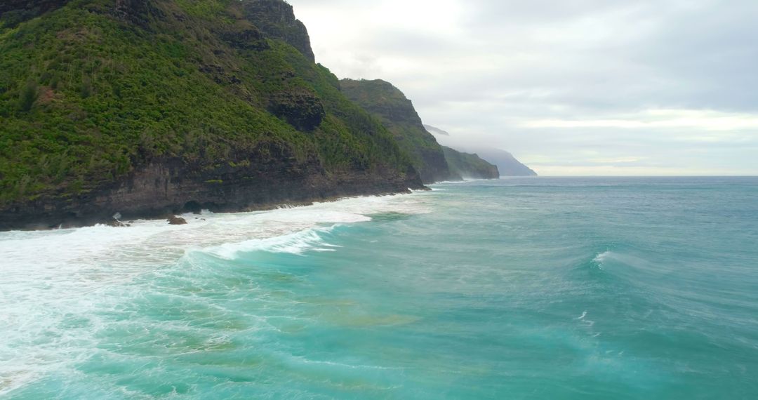Dramatic Coastal Cliffs with Turquoise Waves in Misty Weather - Free Images, Stock Photos and Pictures on Pikwizard.com