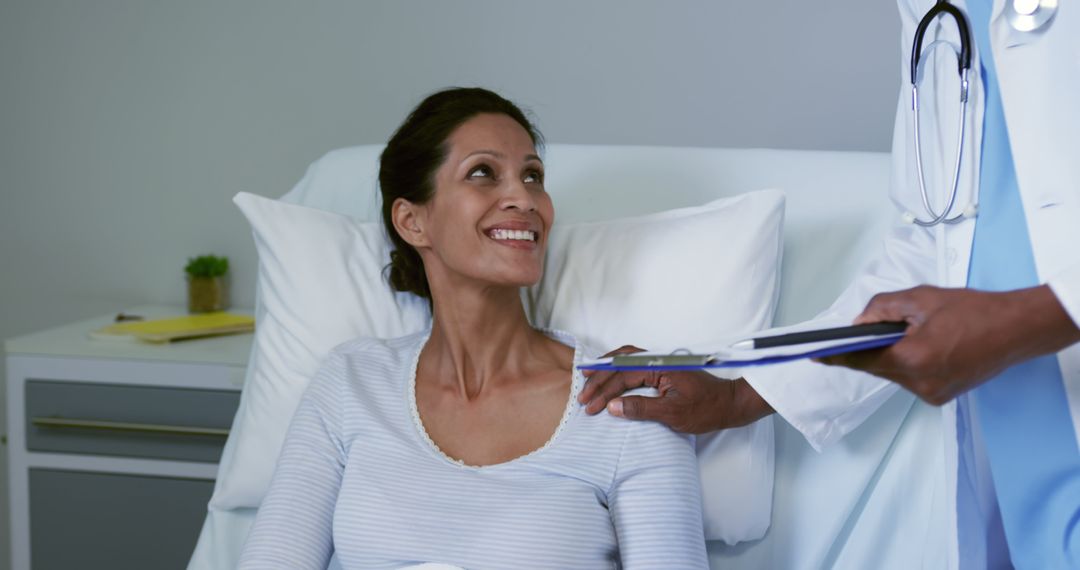 Cheerful Female Patient Interacting with Doctor Bedside in Hospital Room - Free Images, Stock Photos and Pictures on Pikwizard.com