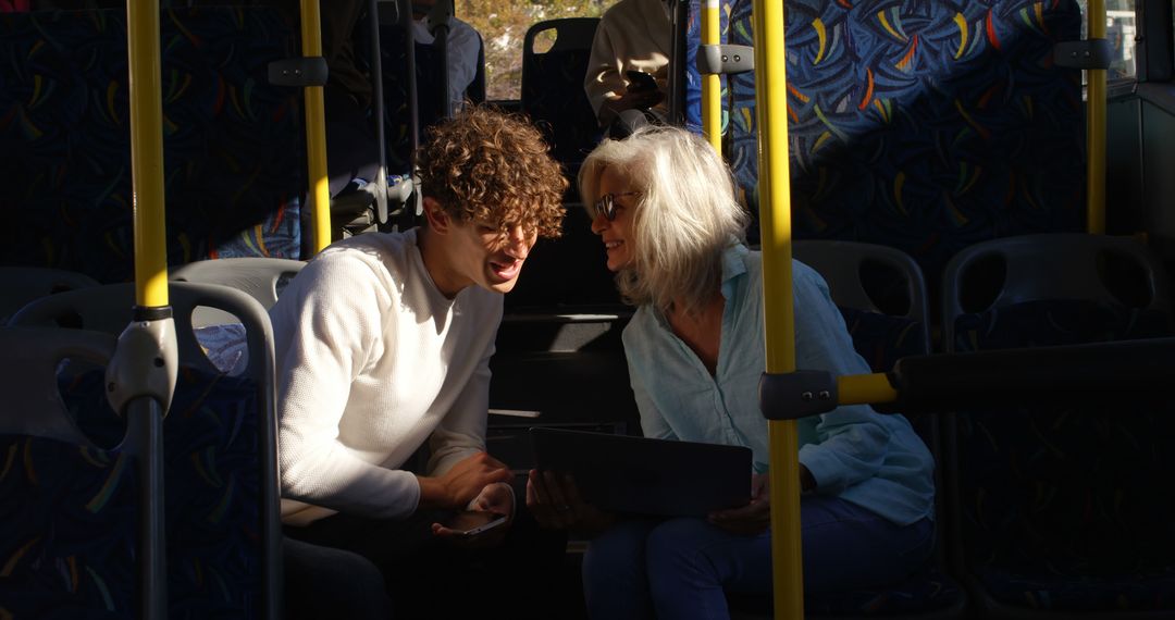 Senior Woman and Young Man Sharing a Laugh and Using Tablet on Public Bus - Free Images, Stock Photos and Pictures on Pikwizard.com