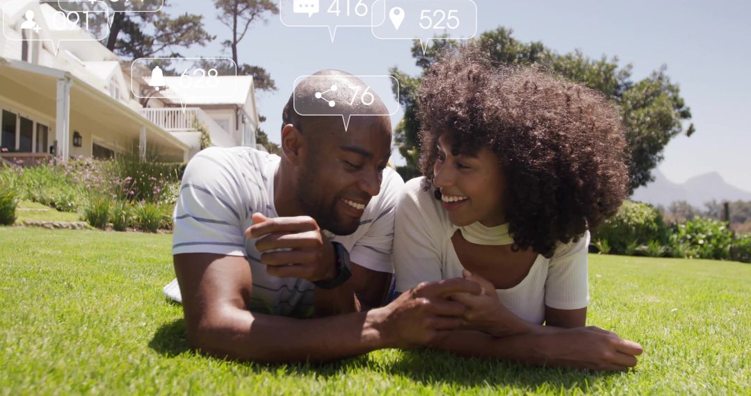 Happy Couple Relaxing on Grass with Digital Connections