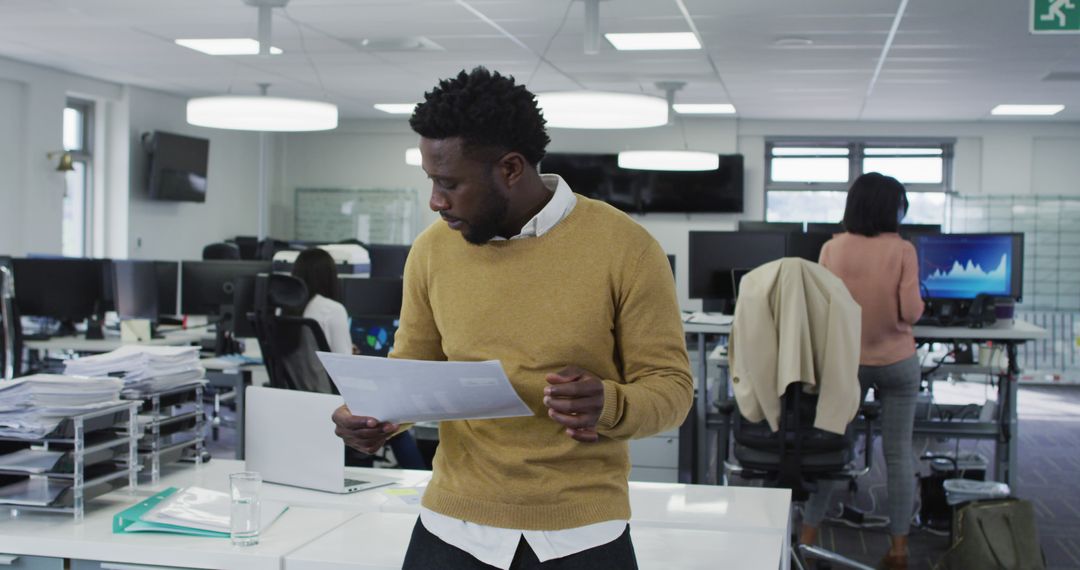 Businessman Standing in Modern Office Analyzing Report - Free Images, Stock Photos and Pictures on Pikwizard.com