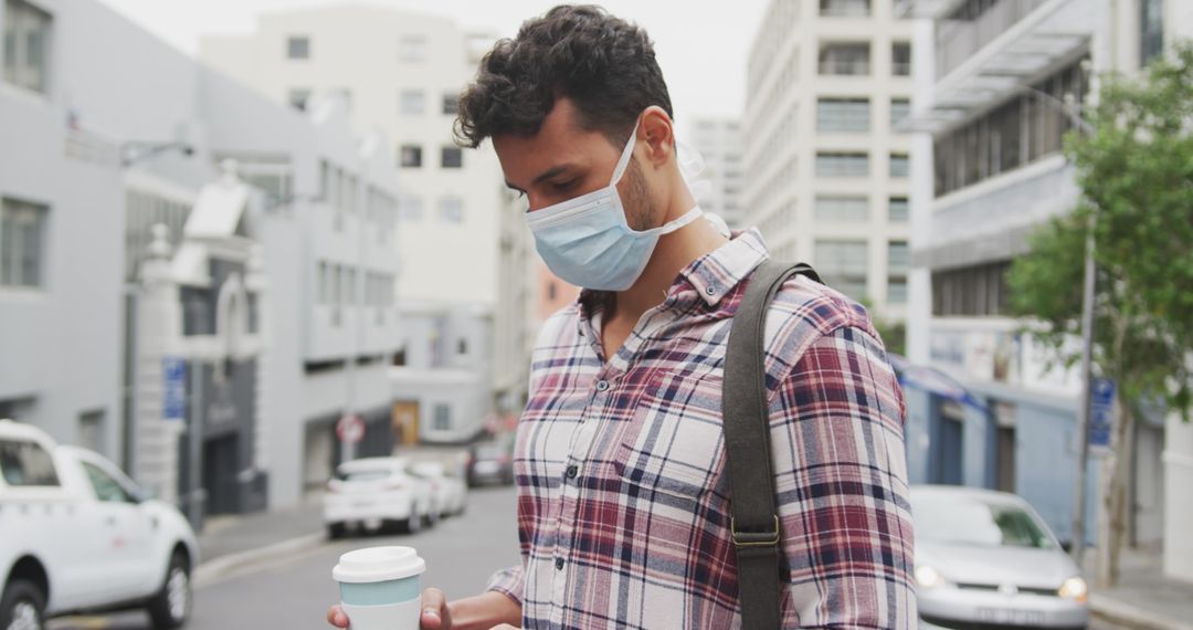 Caucasian Man in Face Mask Using Smartphone Outdoors