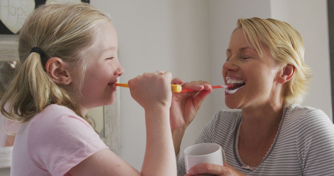 Mother and Daughter Brushing Teeth Together and Laughing - Free Images, Stock Photos and Pictures on Pikwizard.com