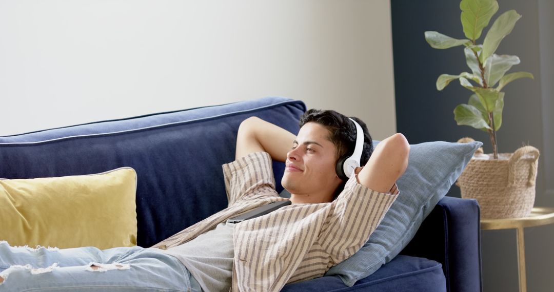Relaxed Man Listening to Music on Couch, Enjoying Leisure Time
