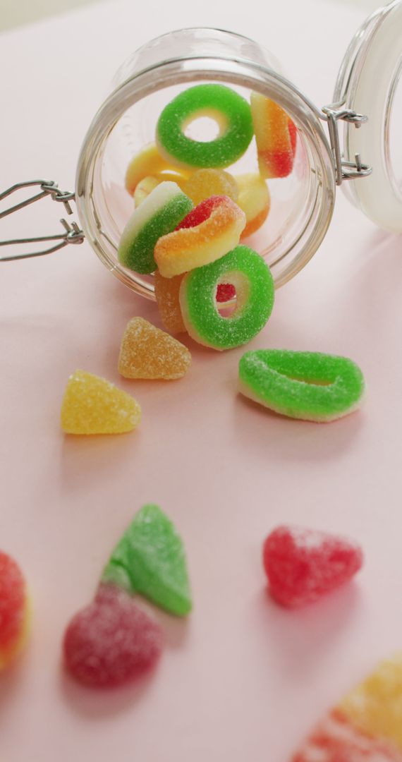 Colorful Jelly Candy Spilling Out of Glass Jar on Pink Background - Free Images, Stock Photos and Pictures on Pikwizard.com