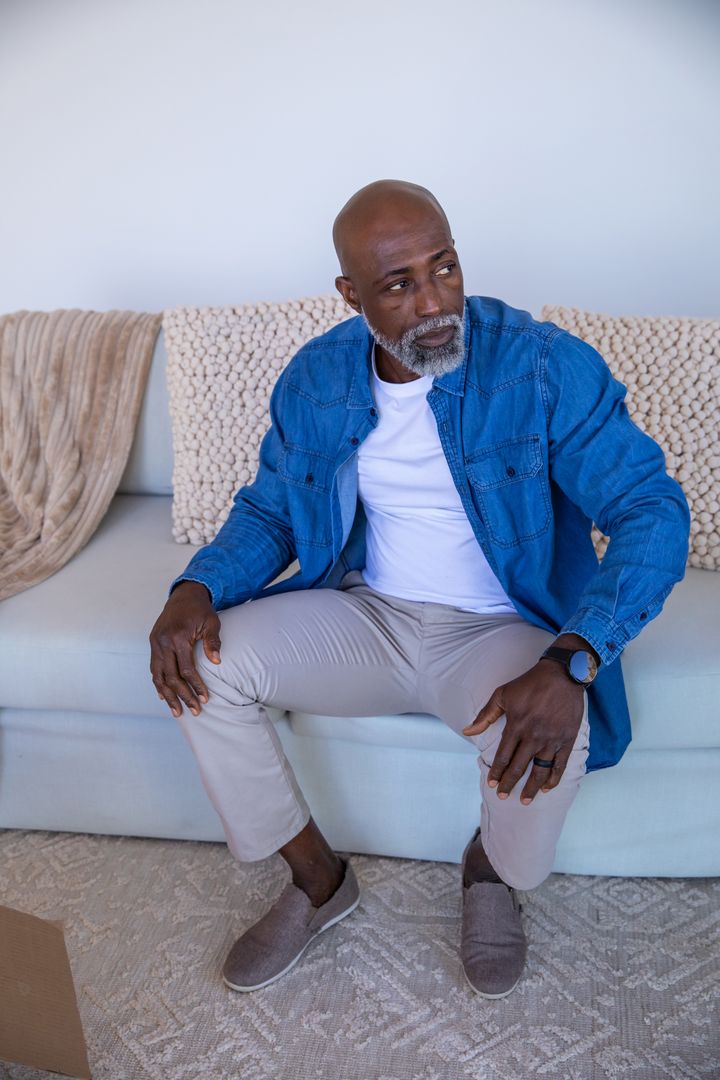 Senior Man Relaxing on Sofa in Contemporary Living Space