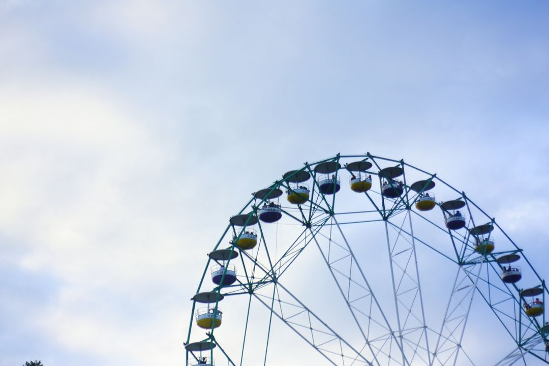 Colorful Ferris Wheel Against Cloudy Sky - Free Images, Stock Photos and Pictures on Pikwizard.com