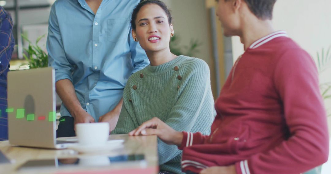 Team Discussion at Office Table with Coffee and Technology
