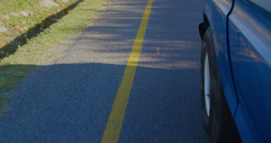 A car travels on a road marked with a yellow line, with copy space - Free Images, Stock Photos and Pictures on Pikwizard.com