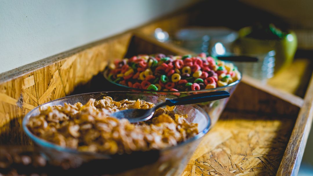 Colorful Breakfast Cereal Bowls with Spoons on Rustic Wooden Serving Counter Close-up