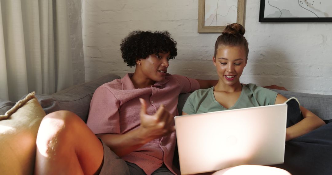 Diverse Couple Relaxing on Sofa with Laptop at Home