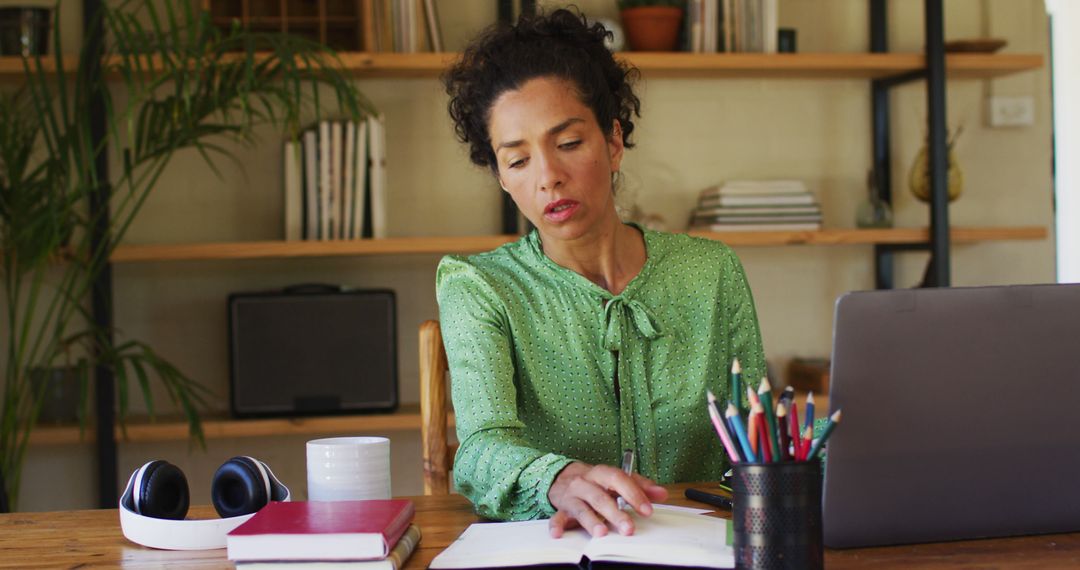 Biracial woman taking notes while working from home - Free Images, Stock Photos and Pictures on Pikwizard.com