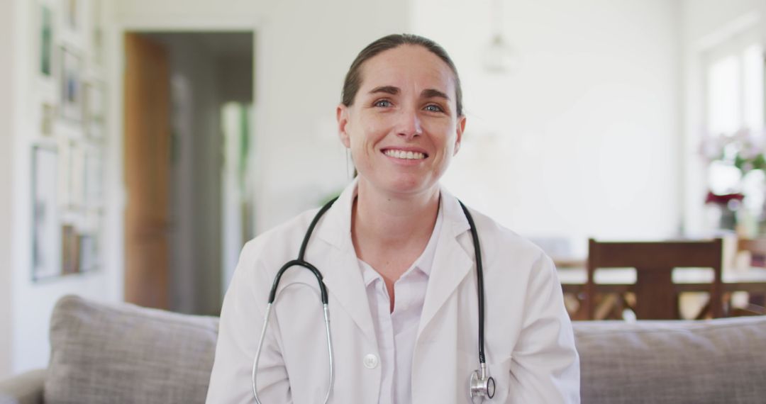 Smiling Female Doctor Sitting on Sofa Engaging in Video Call at Home