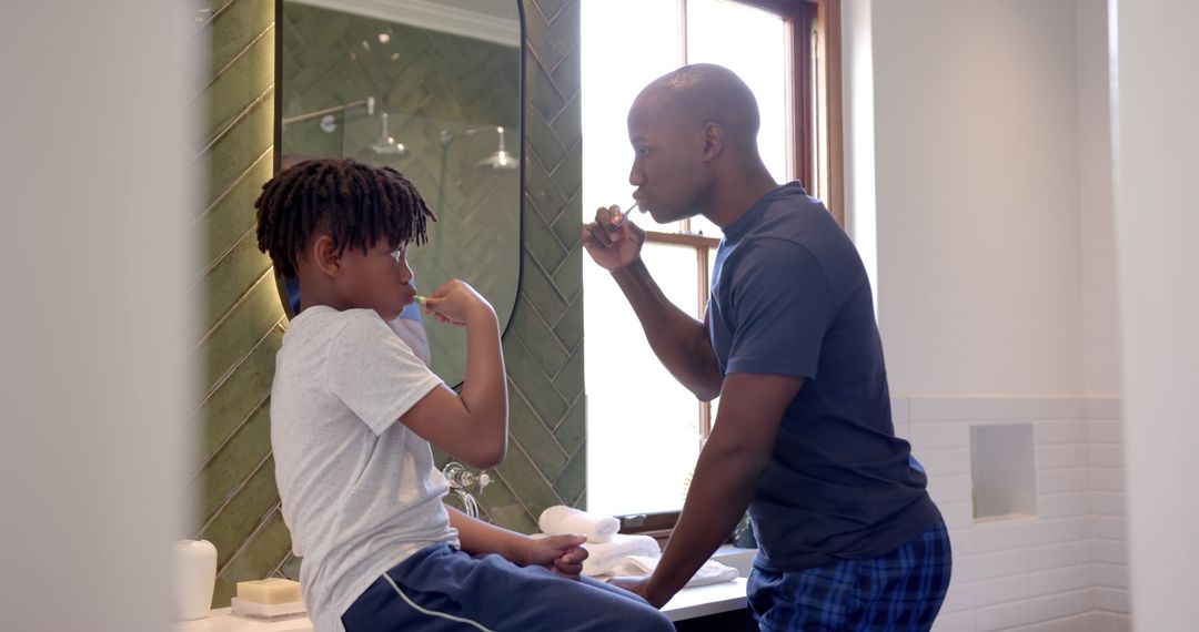 Father and son brushing teeth together in bathroom mirror - Free Images, Stock Photos and Pictures on Pikwizard.com